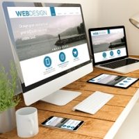 Digital generated devices over a wooden table with responsive design website. All screen graphics are made up.